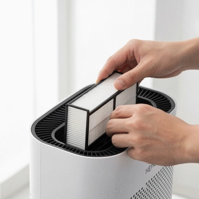Hand replacing a HEPA filter in an air purifier, clean background
