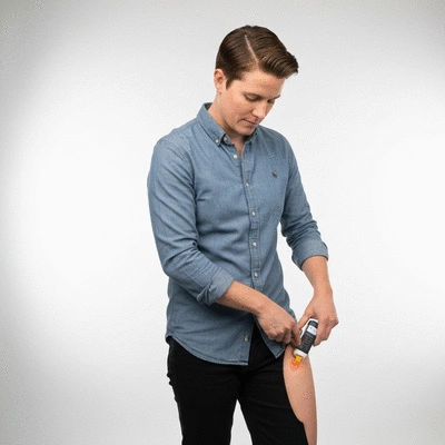 A person demonstrating how to use an EpiPen trainer on their thigh, in a clear, well-lit environment